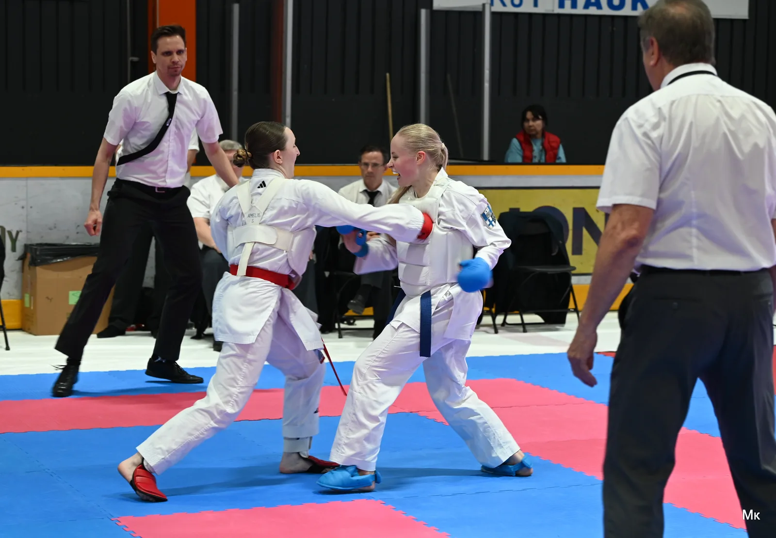 Two women in a kumite match wearing standard chest protection